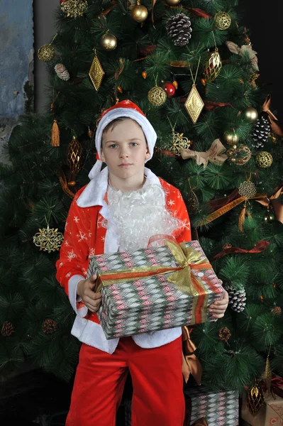 Niño pequeño en traje de Santa Claus de pie alrededor de la Navidad t — Foto de Stock