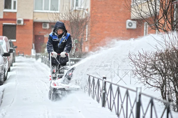 St. Petersburg, Rusland - 12 januari 2016: een man verwijdert sneeuw in — Stockfoto