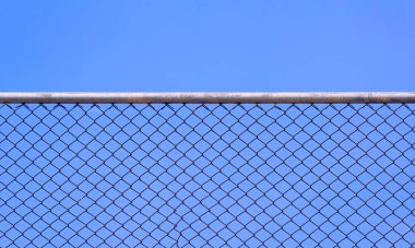 Mavi gökyüzü arka planına karşı eski çelik ağ çiti