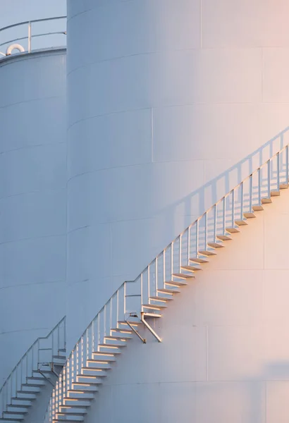 垂直框架白色储油罐弧形螺旋楼梯表面上的晨光 — 图库照片