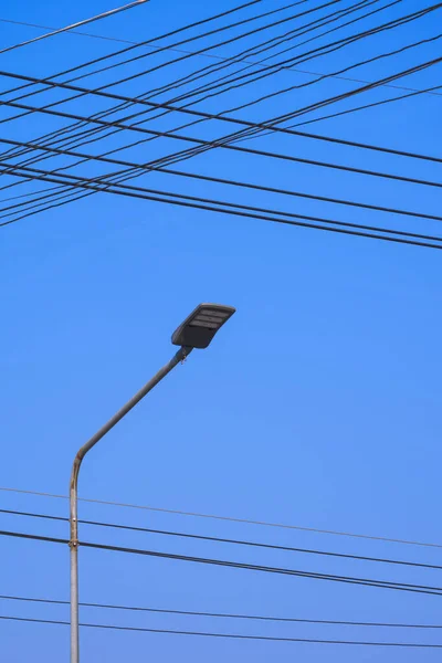 Niedrige Ansicht Von Straßenlaternenmasten Mit Belebten Stromleitungen Vor Blauem Himmelshintergrund — Stockfoto