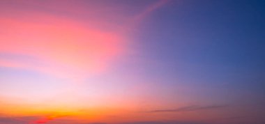 Canlı turuncu, pembe ve mor gradyanlı dramatik alacakaranlık panoramik gökyüzü. Yumuşak bulutlu güzel günbatımı arkaplanı ve tasarım için kopyalama alanı. Alacakaranlıkta doğal renkli gökyüzü arkaplanı.