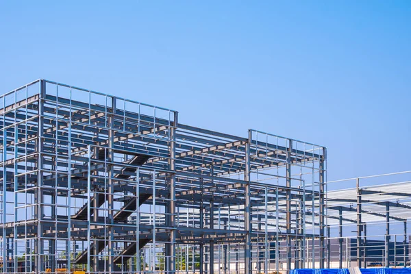 Modern endüstri ofis binasının metal iskeleti mavi gökyüzüne karşı endüstriyel fabrika şantiye alanı, perspektif yan görünüm