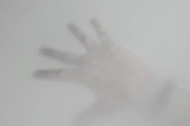 Korkuyu ifade eden bir bezin arkasında el.