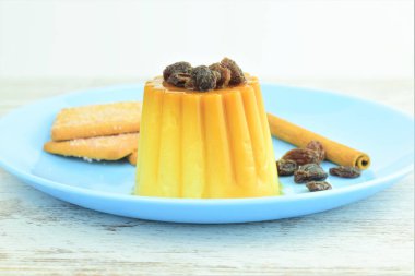 Üzümlü turta, yanında tarçınlı kurabiyeler, mavi yuvarlak bir tabakta.