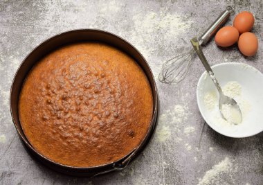 Ev yapımı kek, malzemeler ve çatal bıçakların bir parçası. Taş bir tabanda ve zirvede.