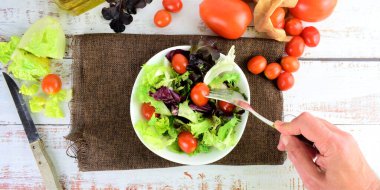 Zenith manzaralı, çatallı, beyaz kaseli, çeşitli salatalı bir domates topluyor.