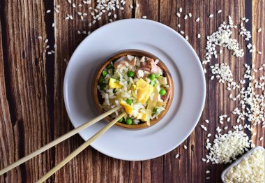 Pirinç üç lezzet, ahşap bir kasede, uzun çubuklarla birlikte. Zirve görünümü.