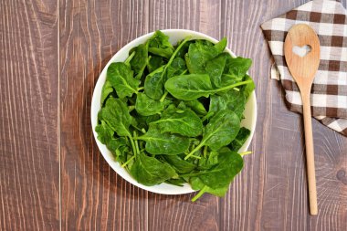 Beyaz bir kâse içinde taze ıspanak yaprakları..