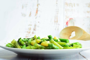 Beyaz bir tabakta servis edilen karidesli kuşkonmaz, baharat, kekik ve zeytinyağı. Boşluğu kopyala.