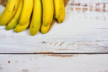Group of bananas on white rustic table. Copy space
