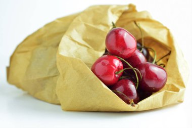 Kraft kağıdındaki kirazlar kirlenmiş plastik torbalardan kaçınıyor..