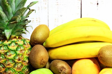 Egzotik, tropikal ve çeşitli mevsimlik meyveler, kırsal beyaz ahşap arka plan.