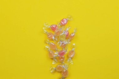 Sarı arka planda çeşitli aromalı şekerler. Boşluğu kopyala
