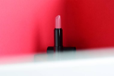 Açık pembe ruj, kırmızı arkaplan dış hat, ön beyaz gradyan, kopyalama alanı.