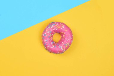 Renkli erişteli çörek, tatlı. İki renkli arka plan ve genel görünüm..