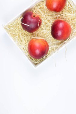 Zenith manzarası. Bir kutu içinde nektarin grubu. Beyaz arkaplan ve kopyalama alanı.