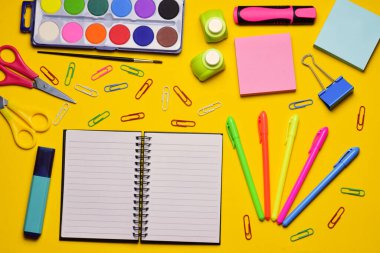 Sarı arka planda çeşitli okul aksesuarları, zirve manzarası.