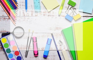 Açık renkli kırsal ahşap üzerinde çeşitli okul malzemeleri. Okula dönelim. Orta alandaki boşluğu şeffaflıkla kopyala.