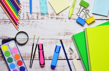 Açık renkli kırsal ahşap üzerinde çeşitli okul malzemeleri. Okula dönelim. Boşluğu merkez alanda kopyala.