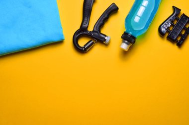 Bronz sarı arka planda fitness eğitimi ve çeşitli aksesuarlar. Zirve görünümü ve boşluk kopyala.