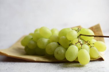 Küçük bir kese kağıdında bir demet üzüm. Taş arkaplan, kopyalama alanı.