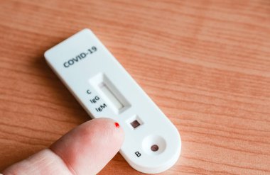 Kan damlası olan parmağın yakın çekimi covid-19 IgG / IgM hızlı test için hazır.  .