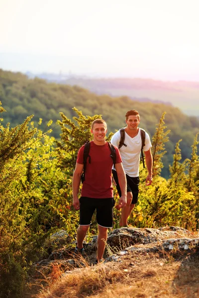 Dos hombres caminando en la cima de la montaña — Foto de Stock