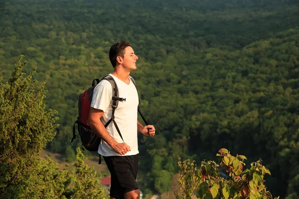 Cose up di uomo sorridente con zaino sul backgound natura — Foto Stock