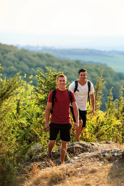 Dos hombres caminando en la cima de la montaña — Foto de Stock