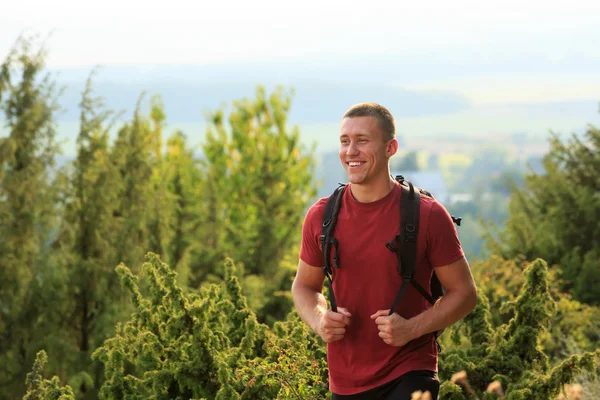 Close up of smiling young man hiking with backpack — Stock Photo, Image