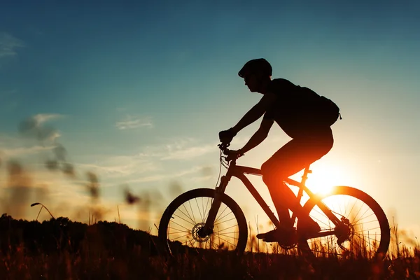 Uomo Ciclista con bici al tramonto — Foto Stock