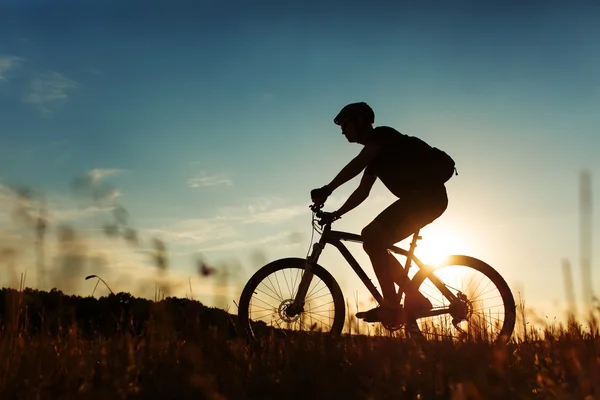 Man cyklist med cykel på sunset — Stockfoto