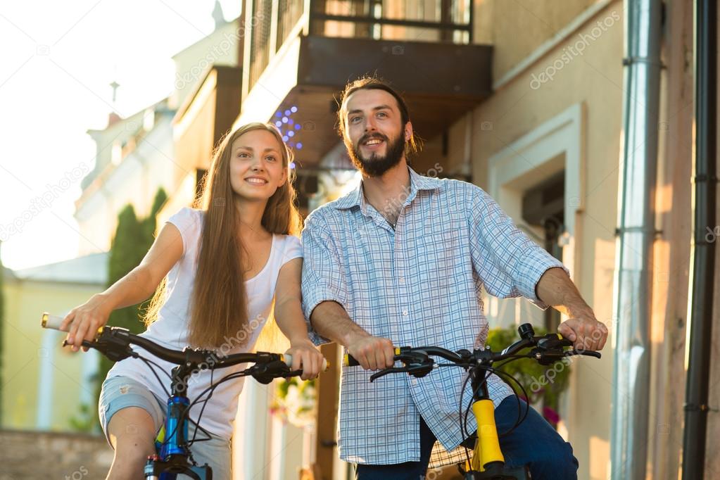 Close up of young loving couple with bikes nearby wall