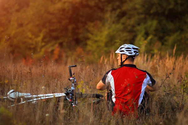 Jovem senhora bonito posando em uma bicicleta perto da parede — Fotografia de Stock