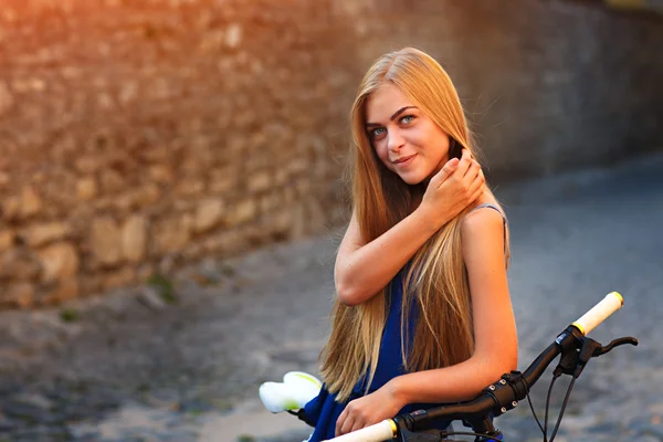 Jovem senhora bonito posando com bicicleta perto da parede — Fotografia de Stock