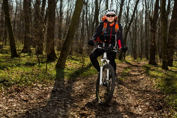Mountainbike-cyklist ridning på cykel i springforest landskap. — Stockfoto