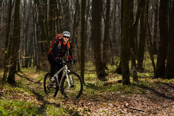 Ciclista de montaña montando en bicicleta en el paisaje del bosque de primavera . — Foto de Stock