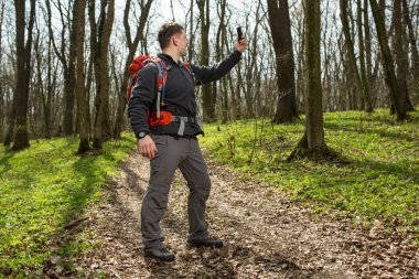Adam uzun yürüyüşe çıkan kimse alarak fotoğraf ormandaki akıllı telefon ile