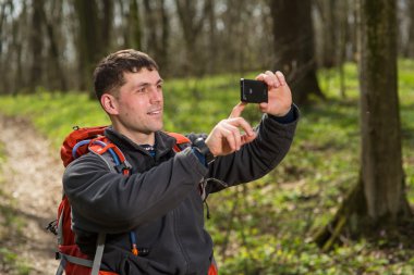 Adam uzun yürüyüşe çıkan kimse alarak fotoğraf ormandaki akıllı telefon ile
