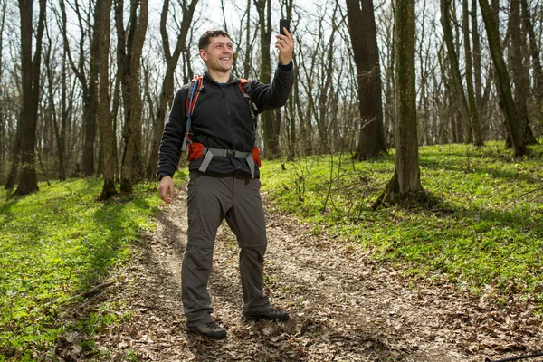 男子徒步旅行者在森林里的智能手机合影 — 图库照片