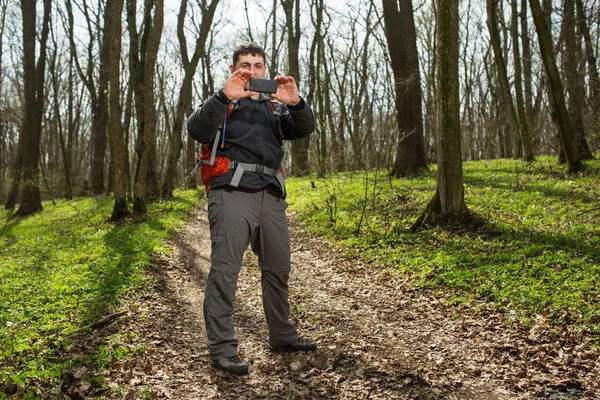 Adam uzun yürüyüşe çıkan kimse alarak fotoğraf ormandaki akıllı telefon ile