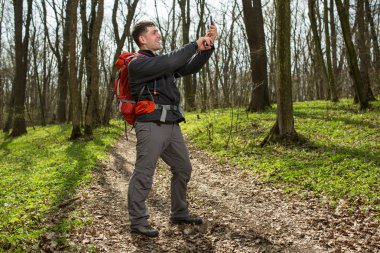Adam uzun yürüyüşe çıkan kimse alarak fotoğraf ormandaki akıllı telefon ile