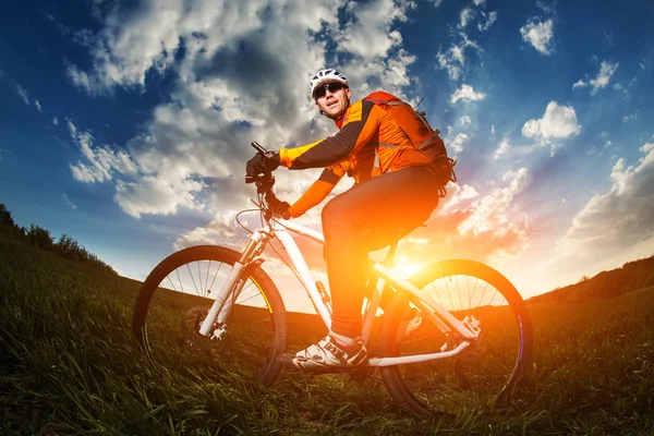 Rowerzysta z rowerem na łące — Zdjęcie stockowe