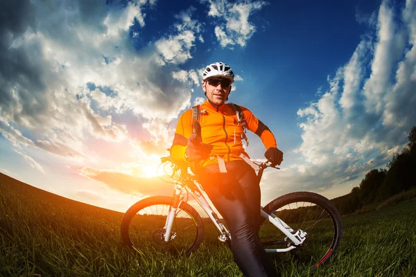 Radfahrer mit dem Fahrrad auf Wiese — Stockfoto