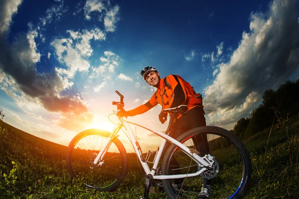 Széles látószögű portré, kék ég, a mountain bike kerékpáros ellen — Stock Fotó