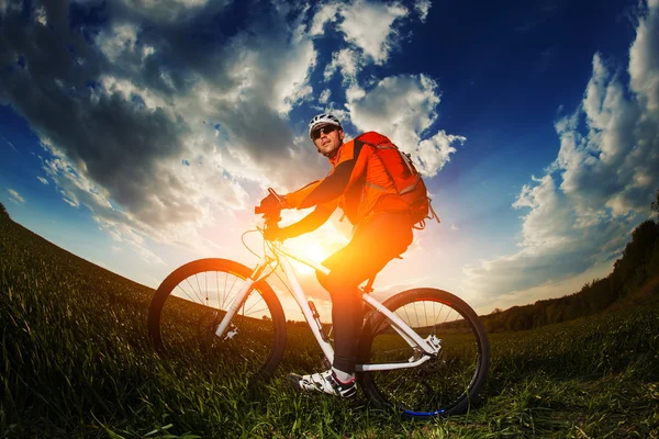 Retrato de ângulo largo contra o céu azul do ciclista ciclista de montanha — Fotografia de Stock