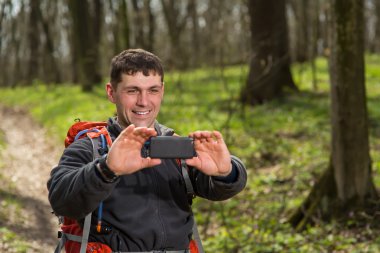 Adam backpacker fotoğraf makinesini ormandaki yapmak