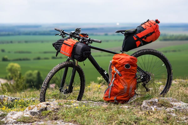 Bicicleta con bolsas naranjas para viajar — Foto de Stock