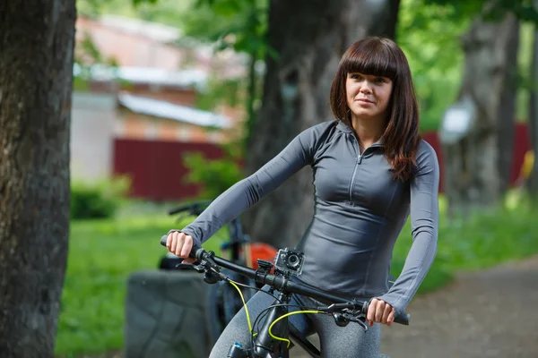 Cyklist kvinna cyklar i parken — Stockfoto